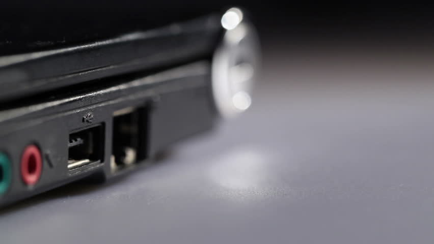 Inserting red usb flash drive in notebook with focus accentuate on it. Macro shot.