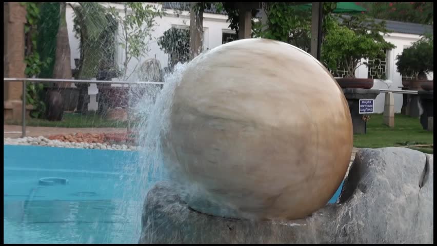 Spinning Ruby Stone with Water: A heavy round granite stone is amazingly spinned by the nimble  power of water. Located at the Bonsai Garden, Sri Ganapathy Sachchidananda Ashrama. Mysore, India.