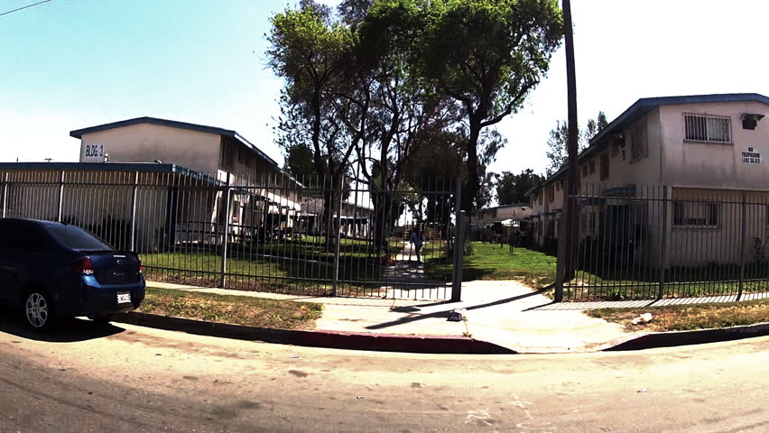 WATTS, CA - APRIL 9, 2013: The point of view of someone driving by federally funded apartments or projects circa 2013 in Watts. An economically depressed community in the Los Angeles Metro Area.
