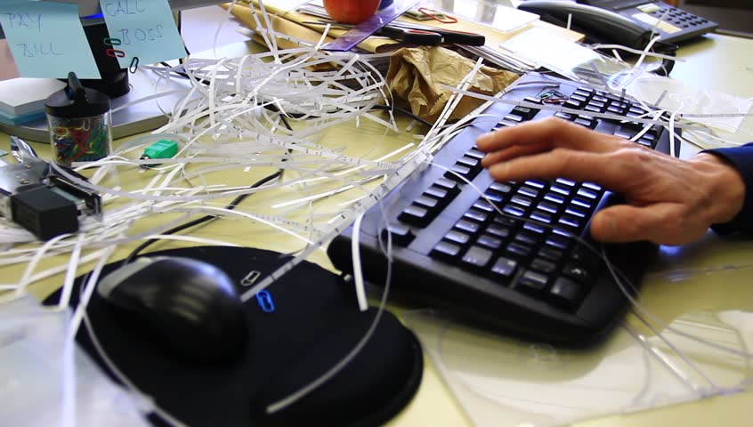 Lazy worker typing. Messy office.