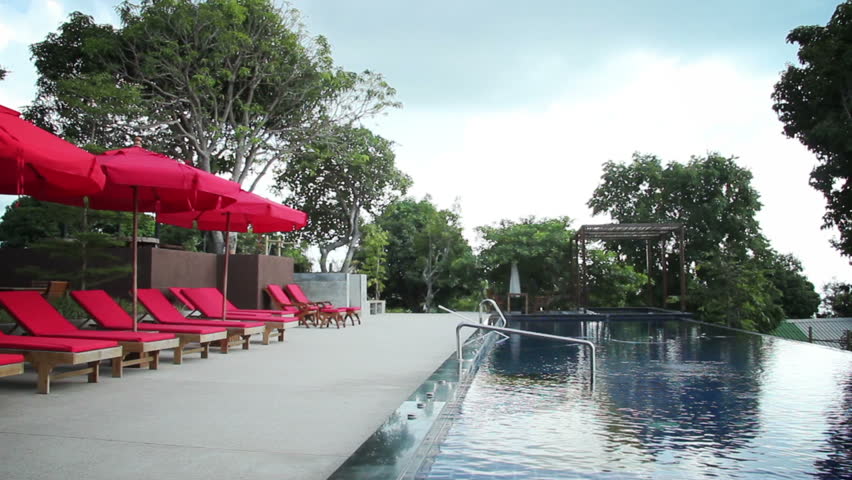 Sunbeds on a deck beside a large swimming pool in a tourist resort
