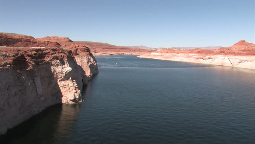 Lake Powell upstream from Glen Canyon Dam Bridge at Page Arizona.  From top of the dam. Colorado River. Red rock sandstone cliff and ledge. Dry desert. 
