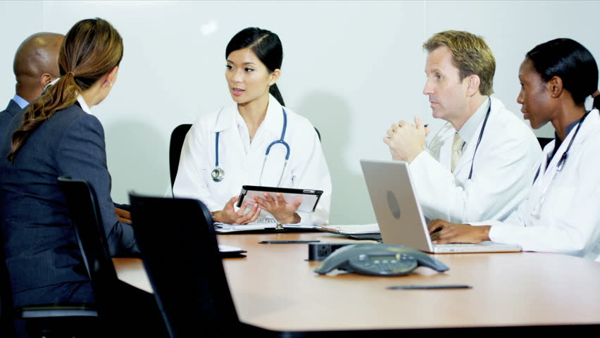 Multi ethnic team medical doctors receiving budgets advice from financial consultancy shot on RED EPIC