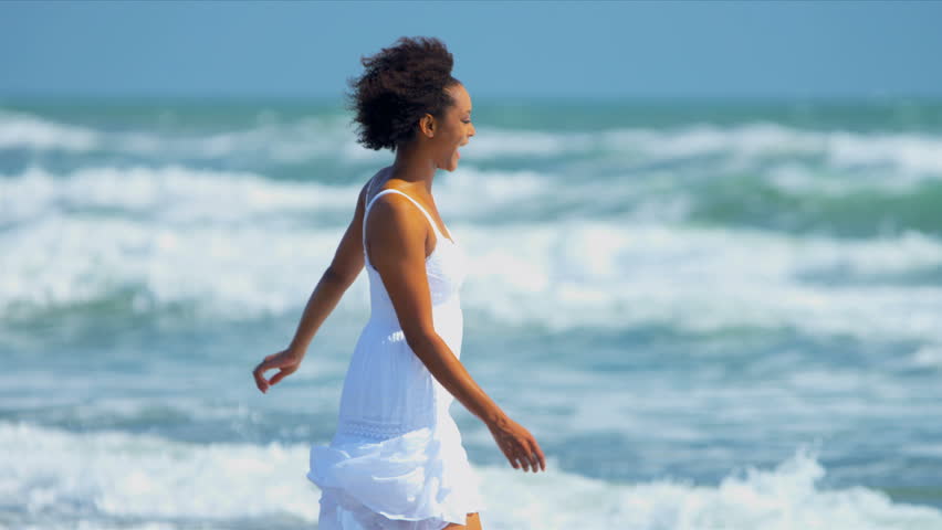 Beautiful African American female reveling in her lifestyle beside a tropical ocean shot on RED EPIC