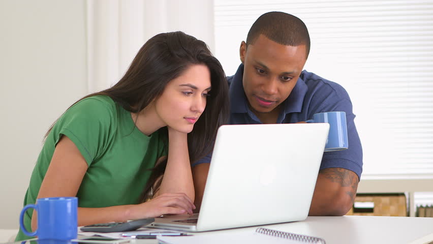 African american and caucasian couple paying bills together
