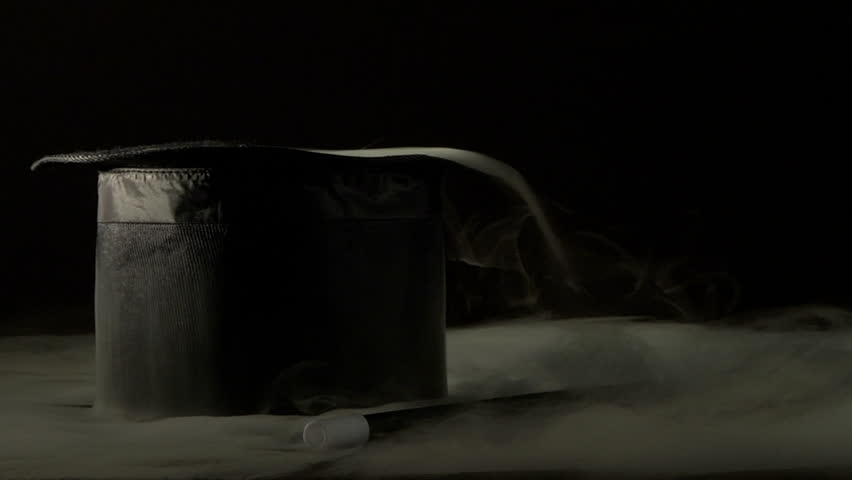 Magic hat and wand in smoke - A spot lit black top hat and wand are engulfed in dry ice.