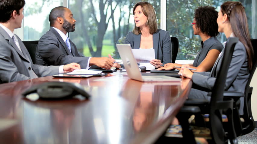 Female Caucasian team leader chairing boardroom meeting multi ethnic business colleagues