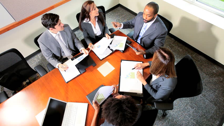 Team smart multi ethnic financial traders using wireless technology to receive good news