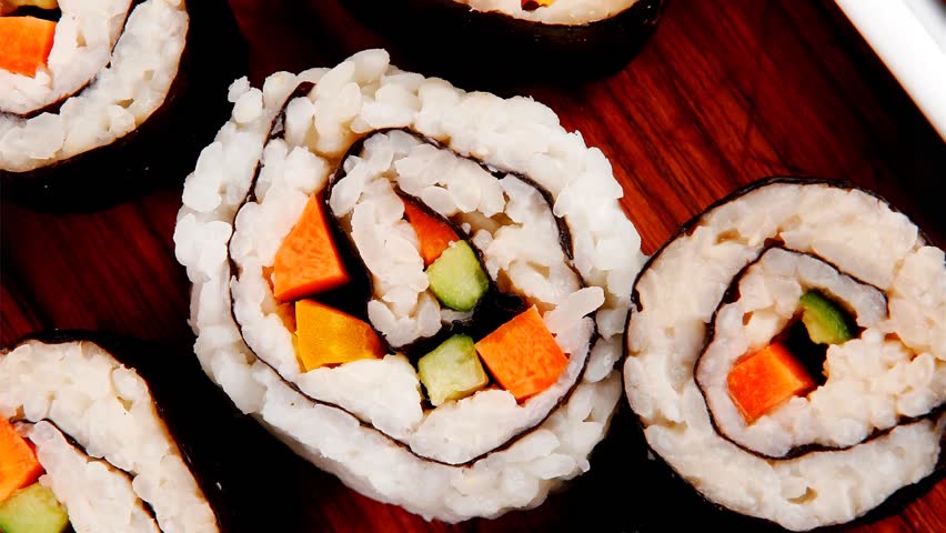 Japanese traditional Cuisine - Roll with Cucumber Cream Cheese with raw Tuna(maguro) and Salmon(sake) inside. on wooden plate with wasabi and ginger isolated over white background