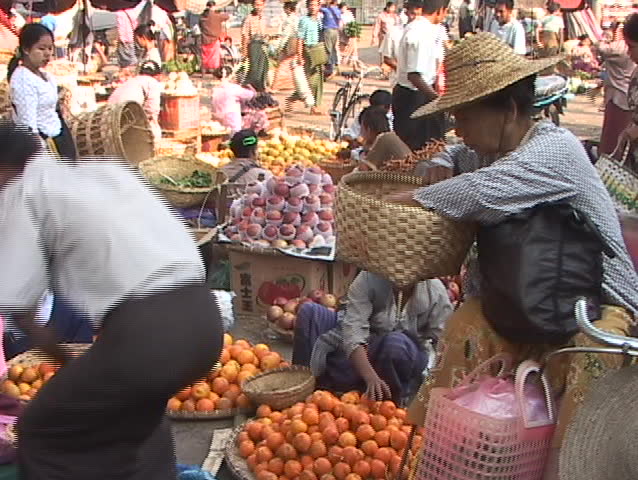 burma scenes: woman vendor at market in Mandalay smoking cigar