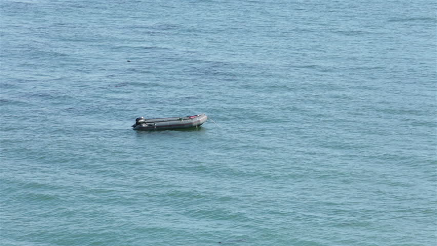 Ocean rubber diving boat anchored on water. Summer recreation and sport rubber boat anchored off coast of Northern California. Used for fishing and sport diving. 