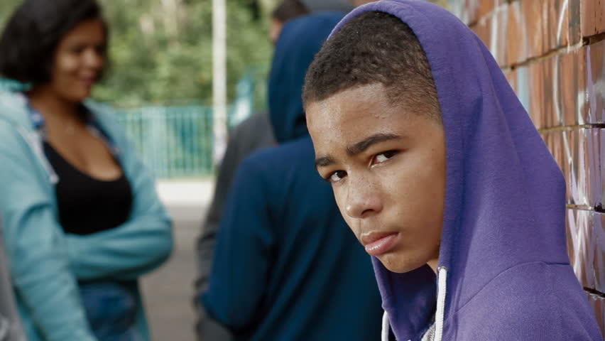 PORTRAIT: Teenage boy in hoodie looking to camera