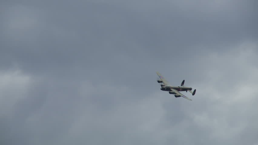 Avro Lancaster bomber plane from World War II flies past followed by a Spitfire fighter.