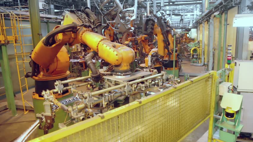 Robots weld car components in production line at factory