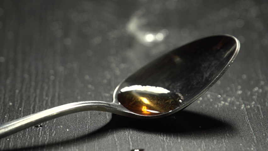 Close up of man filling the syringe up with heroin