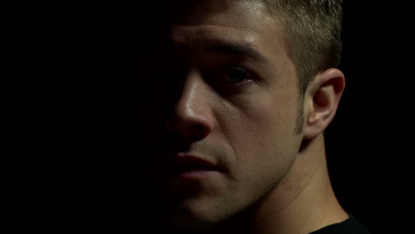 Man's profile, then turns to camera in color. Experimental lighting