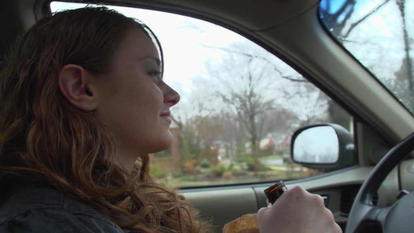 Young woman drinking and driving