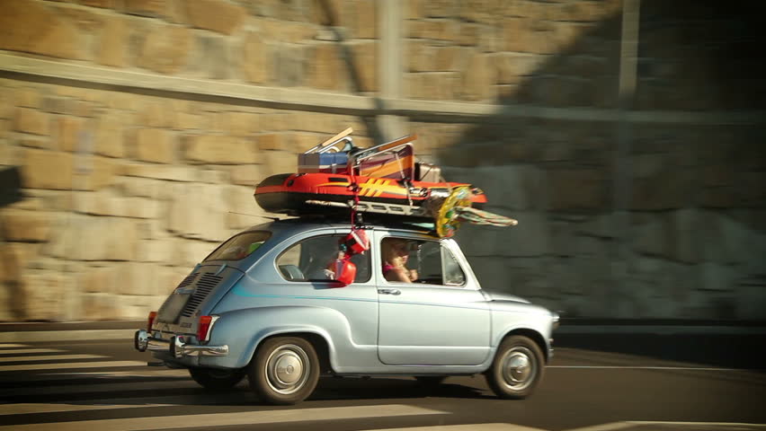 Family car filled with stuff for children play on the road toward summer holidays
