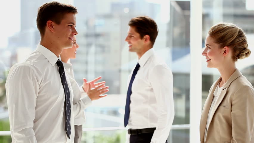 Business people shaking hands and walking away in busy modern office