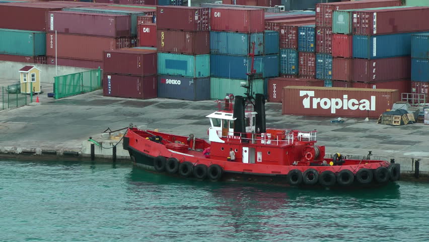 ST THOMAS, US VIRGIN ISLANDS - MAY 2012: Tug boat anchored by the containers of St Thomas harbor to check them before the loading operations