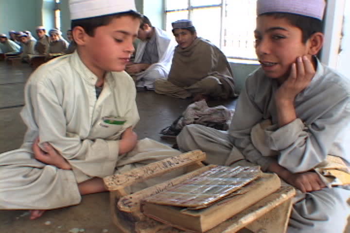 PESHAWAR, PAKISTAN - NOVEMBER 01, 2001: Two boys rock back and forth as they recite the Koran inside the Saudi-funded Darul Uloom Junadia Ghafooria.