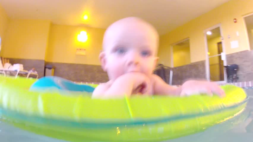 Underwater shot of a cute little baby boy at the swimming pool with his family.
