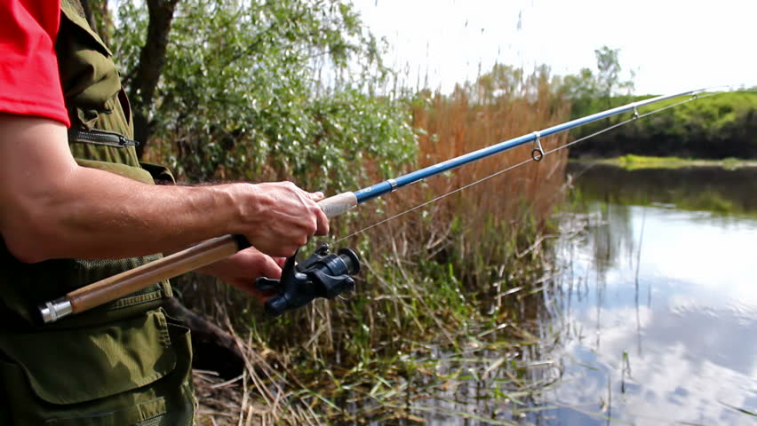 sport fisherman fishing on a river bank with fishing rod,video clip ; fishery