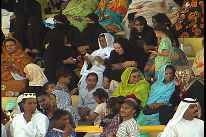 DUBAI - NOVEMBER 02, 2001: General views of Jebel Ali Race Course; MS women and children sitting apart from the men. Many are in brightly colored scarves and veils, some are in black hijab.