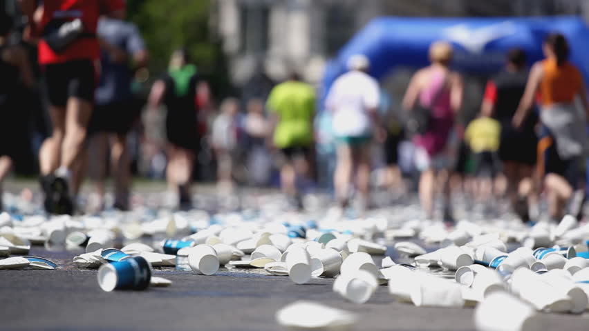 paper and plastic cups at marathon supply station, people blurred