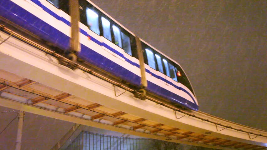 Train moving on metro bridge in heavy snow in the evening on close up