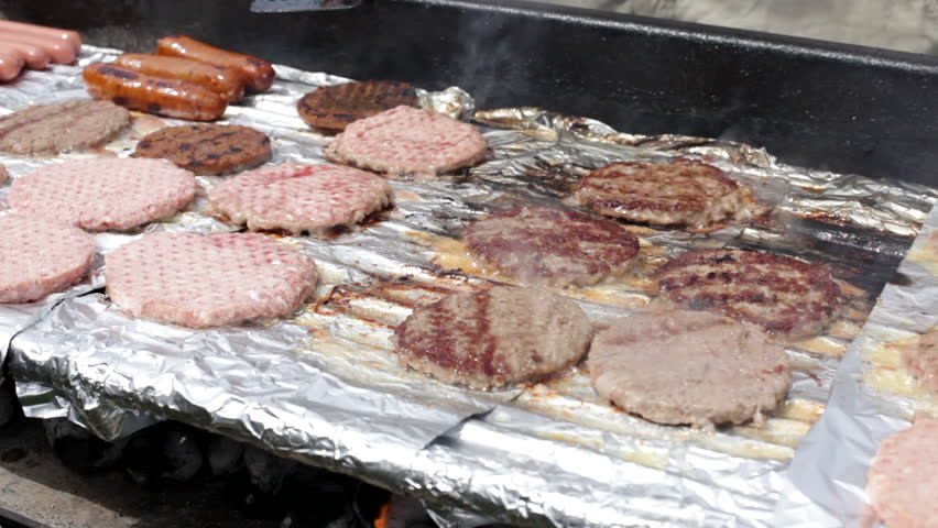 Burgers and hot dogs cooking on grill