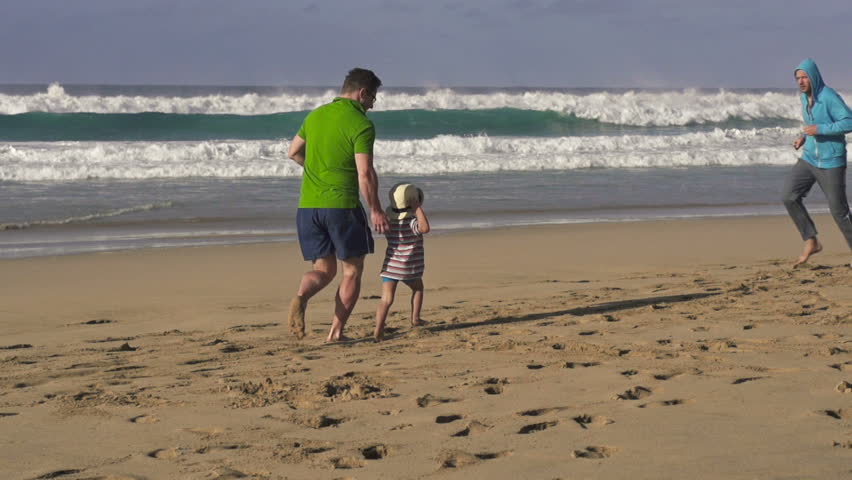 Father, son and joggers on the beach, super slow motion, shot at 240fps
