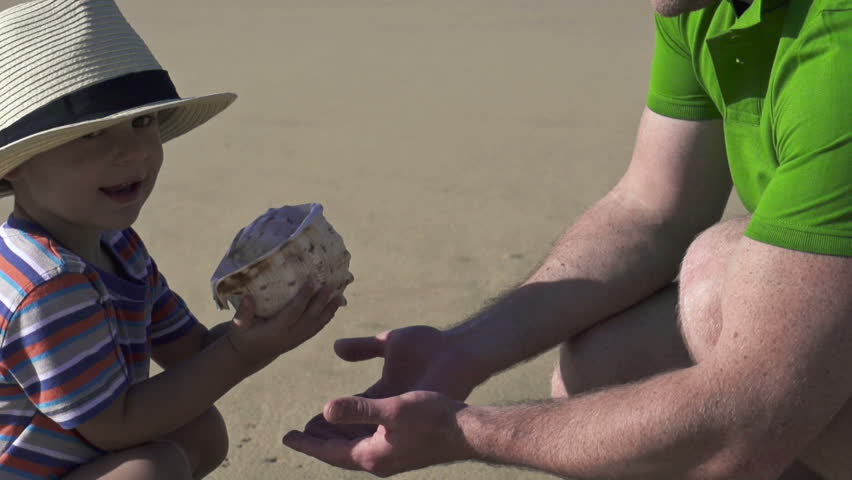 Father and son with beautiful seashell, super slow motion, shot at 240fps
