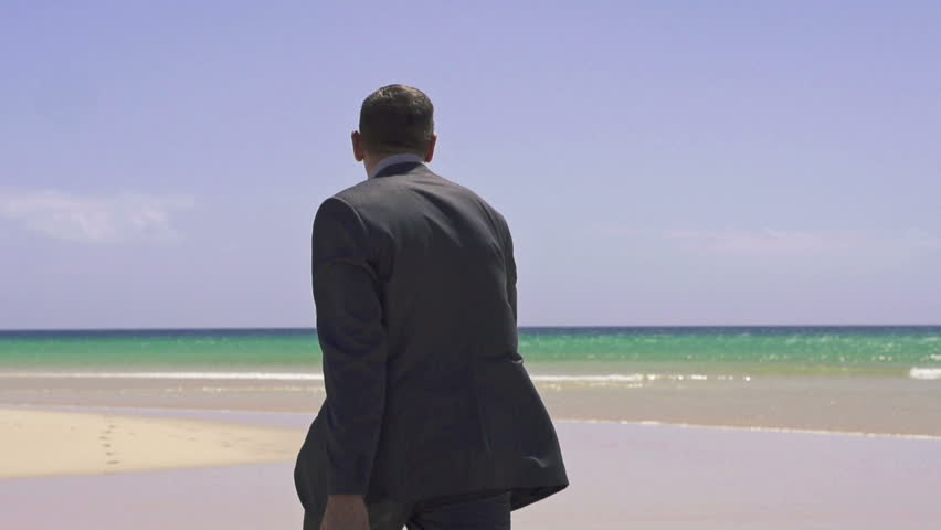 Businessman with suitcase walking on exotic beach, super slow motion, shot at 240fps
