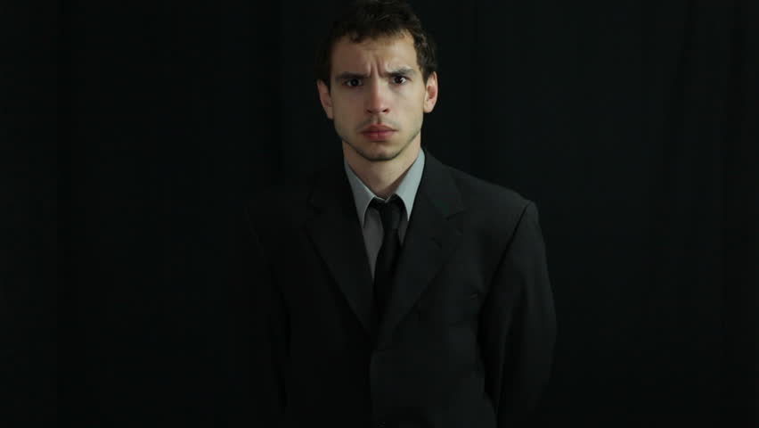 Serious businessman over dark background