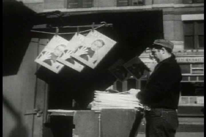 1940s - Archival film depicting blank newspapers being delivered to a newsstand in a city.