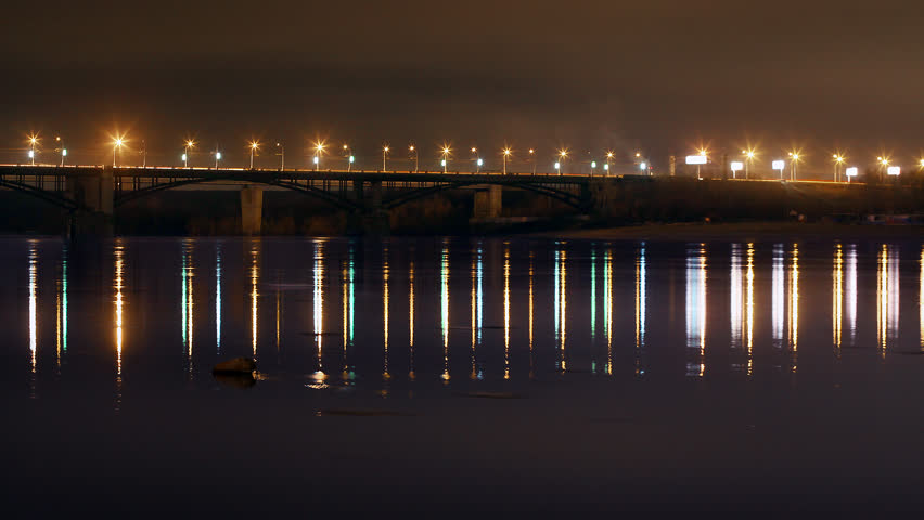 The bridge over the river at night with moving cars