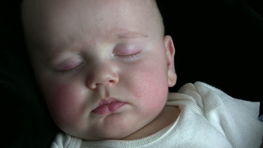 Baby sleeping peacefully with a black background.  HD 1080i