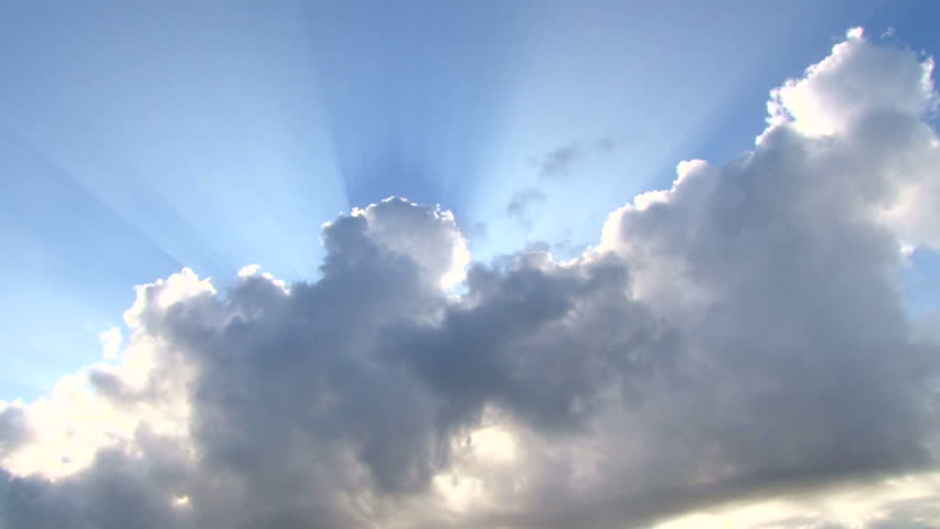 Beautiful cloudscape with large, building clouds and sunrise breaking through cloud mass.