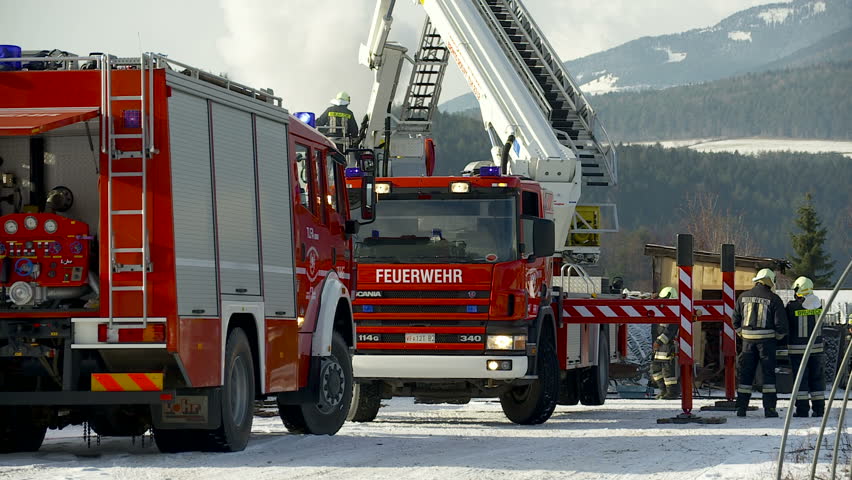 BRUNECK, ITALY - CIRCA 2012: Fire brigade extinguish fire, garden house burns.