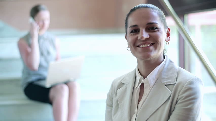 Portrait of smiling businesswoman standing on stairs, interior
