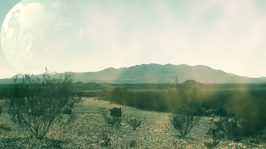 A dust storms blowing across a barren desert landscape all but conceals a large planet moving slowly through the sky.