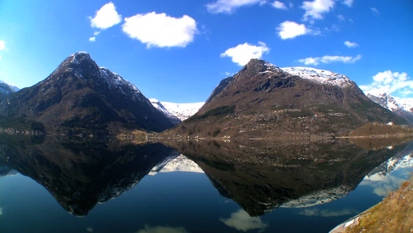 Time-lapse clouds over crystal clear waters of Norway fjord