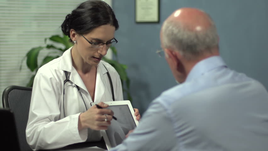 Female doctor showing patient's x-ray with tablet