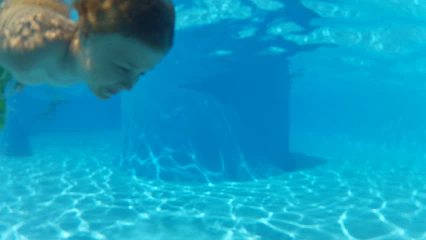 boy swimming underwater in sea or pool 