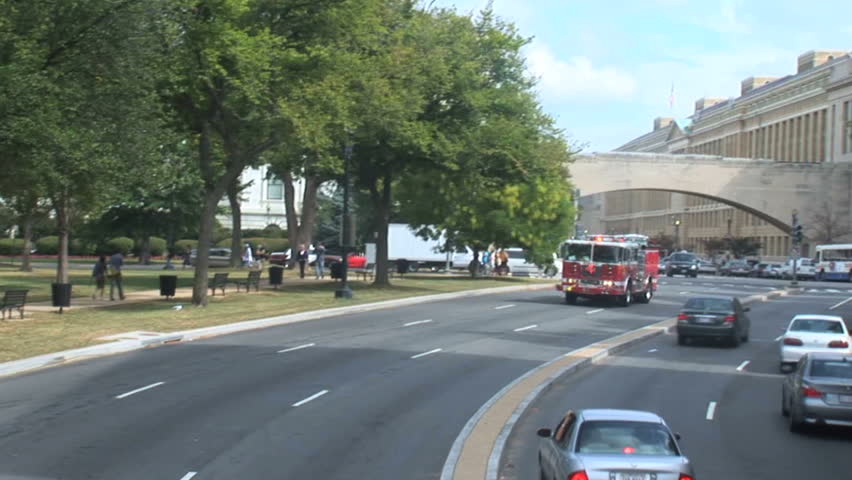 Fire truck with siren and lights on going under a bridge in Washington DC