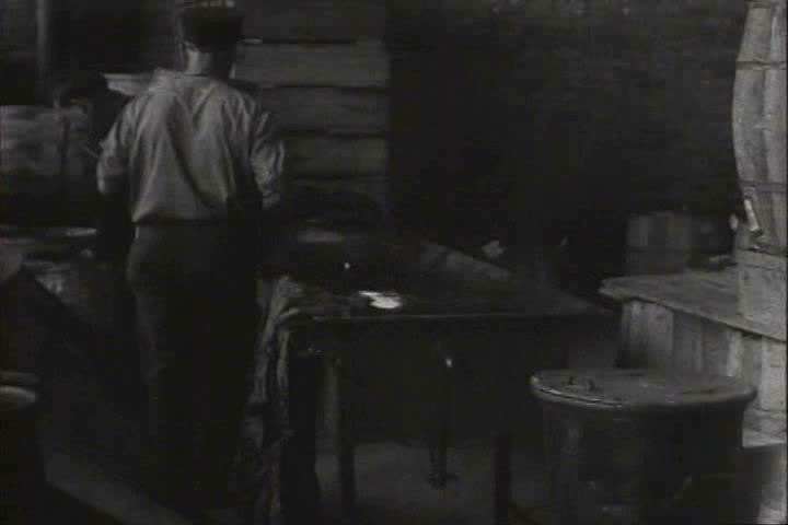 1910s, 1920s - A man puts out a fire in a workshop