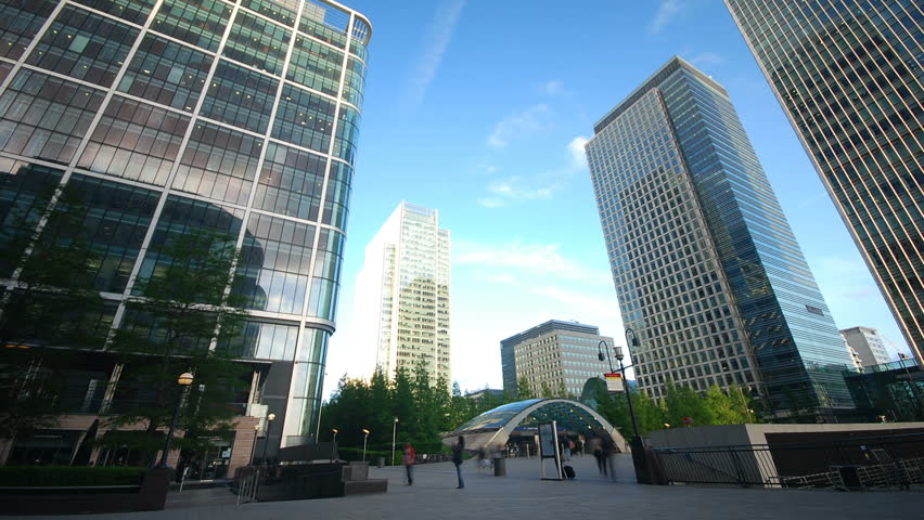Time lapse of business people traveling in front of corporate office buildings and skyscrapers  at Canary Wharf in London 