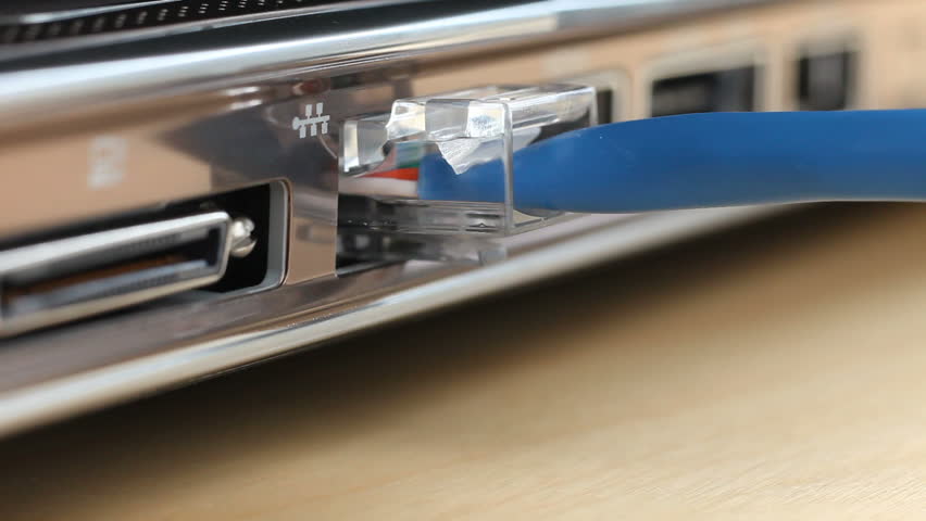 Closeup of ethernet cable being unplugged from laptop computer.