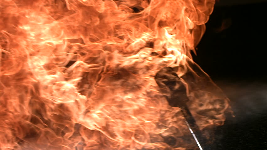 Man breathing fire, pan right, slow motion